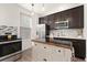 Modern kitchen featuring stainless steel appliances, dark wood cabinetry, and a central island with drawers at 14278 Forest St, Thornton, CO 80602