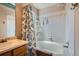 Bathroom with a combination tub and shower, white tiled walls, and a neutral vanity at 4203 E 126Th Ave, Thornton, CO 80241