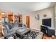 Spacious living room with hardwood floors, a large couch, and a view into the adjacent kitchen at 4203 E 126Th Ave, Thornton, CO 80241