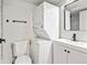 Bathroom featuring a stackable washer/dryer, toilet, and vanity with modern fixtures at 6800 E Tennessee Ave # 541, Denver, CO 80224