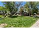 Lush grassy lawn with mature trees and walking paths in front of a multi-story residential building at 6800 E Tennessee Ave # 541, Denver, CO 80224