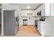 Bright kitchen with white cabinets, stainless steel appliances, and light-toned laminate flooring at 6800 E Tennessee Ave # 541, Denver, CO 80224