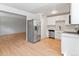 Kitchen displaying white cabinets, stainless steel appliances, and a view into the adjacent living area at 6800 E Tennessee Ave # 541, Denver, CO 80224