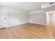 Open living area featuring light laminate flooring, freshly painted white brick and neutral-toned walls at 6800 E Tennessee Ave # 541, Denver, CO 80224