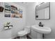 Stylish half bathroom features a pedestal sink, modern fixtures, and elegant decor at 11771 Elk Head Range Rd, Littleton, CO 80127