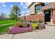 Charming two-story home with beautiful landscaping, water feature, colorful flowers, and lush green lawn at 11771 Elk Head Range Rd, Littleton, CO 80127
