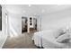 Bright main bedroom features a door to a bathroom, a hat rack, and neutral decor at 11771 Elk Head Range Rd, Littleton, CO 80127