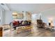 Cozy living room with hardwood floors, a comfortable leather sofa, and a pass through to the dining area at 12338 W Dorado Pl # 107, Littleton, CO 80127