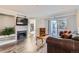 Bright living room showcasing a fireplace, balcony access, and modern flooring for comfortable living at 12338 W Dorado Pl # 107, Littleton, CO 80127