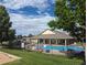 Community pool and clubhouse with lawn and trees at 12338 W Dorado Pl # 107, Littleton, CO 80127