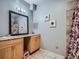Well-lit bathroom featuring a vanity, mirror, and a shower with a stylish floral curtain at 14855 Almstead St, Hudson, CO 80642