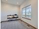 Versatile room with neutral carpet, a large window providing natural light, and space for various uses at 14855 Almstead St, Hudson, CO 80642