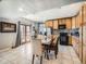 Eat-in kitchen featuring wood cabinets, black appliances, and a dining area, perfect for Gathering meals at 14855 Almstead St, Hudson, CO 80642