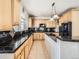 Well-equipped kitchen with black countertops, wood cabinets, and modern appliances, perfect for culinary enthusiasts and Gathering meals at 14855 Almstead St, Hudson, CO 80642