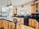 Spacious kitchen featuring wood cabinets, a black tile backsplash, and ample counter space for cooking and entertaining at 14855 Almstead St, Hudson, CO 80642