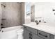 Bathroom featuring gray tiles, a white countertop, a tub with a shower, and black hardware at 6675 Fawn Path Ln, Castle Pines, CO 80108