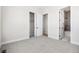 Empty bedroom with light carpet, white trim, a closet with sliding doors, and a view into the bathroom at 6675 Fawn Path Ln, Castle Pines, CO 80108