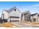 Charming home with gray siding, brick accents, and a two-car garage, enhanced by a red entry door at 6675 Fawn Path Ln, Castle Pines, CO 80108
