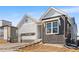 Charming home with gray siding, brick accents, and a two-car garage, enhanced by a red entry door at 6675 Fawn Path Ln, Castle Pines, CO 80108