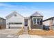 Charming home with gray siding, brick accents, and a two-car garage, enhanced by a red entry door at 6675 Fawn Path Ln, Castle Pines, CO 80108