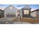 Charming home with gray siding, brick accents, and a two-car garage, enhanced by a red entry door at 6675 Fawn Path Ln, Castle Pines, CO 80108