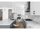 Modern kitchen with white cabinets, a spacious island, stainless steel appliances, and marble backsplash at 6675 Fawn Path Ln, Castle Pines, CO 80108