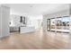 Open-concept kitchen with white cabinetry, a center island, stainless steel appliances, and hardwood floors at 6675 Fawn Path Ln, Castle Pines, CO 80108