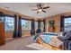 Spacious bedroom featuring neutral carpet, multiple windows with curtains, and a ceiling fan with light fixture at 4275 S Dawson St, Aurora, CO 80014