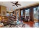 Inviting living room featuring hardwood floors, a ceiling fan, and large windows with custom drapery at 4275 S Dawson St, Aurora, CO 80014