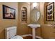 Stylish powder room featuring a pedestal sink, decorative mirror, and elegant accents at 4275 S Dawson St, Aurora, CO 80014