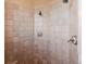 Tiled shower featuring dual shower heads, tile surround, and brushed-nickel fixture at 4275 S Dawson St, Aurora, CO 80014