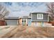 Charming home featuring brick accents, gray siding, solar panels and a well-manicured lawn at 831 Centennial Dr, Bennett, CO 80102