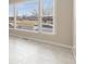 Living room view featuring large windows for natural light, neutral walls, and tile flooring at 5129 Mt Arapaho Cir, Frederick, CO 80504