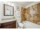 Bathroom showcasing tiled shower and floors, along with a dark vanity at 1430 Fairfax St, Denver, CO 80220