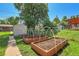 Backyard featuring garden boxes, a shed, and lush grass, perfect for gardening and outdoor enjoyment at 2236 S Osceola St, Denver, CO 80219