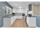 Modern kitchen with white cabinets, subway tile backsplash, stainless steel appliances, and wood-look flooring at 2236 S Osceola St, Denver, CO 80219