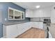Bright kitchen featuring white cabinetry, stainless steel appliances, and a window with natural light at 2236 S Osceola St, Denver, CO 80219