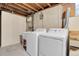 Well-lit basement laundry area with modern washer and dryer, sink, and utility connections at 2236 S Osceola St, Denver, CO 80219