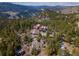 Aerial view of a cozy mountain cabin surrounded by lush trees and mountain views at 3945 Douglas Mountain Dr, Golden, CO 80403