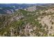 Breathtaking aerial view of a secluded mountain home surrounded by lush forest and stunning mountain ranges at 3945 Douglas Mountain Dr, Golden, CO 80403
