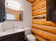 Bathroom featuring log walls, modern sink, and toilet with an elegant mirror at 3945 Douglas Mountain Dr, Golden, CO 80403