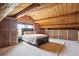 Lofted bedroom with log walls, carpeted floors, sloped ceilings, and built-in storage at 3945 Douglas Mountain Dr, Golden, CO 80403