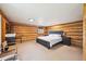 Bedroom featuring wood-paneled walls, carpeted floors, and a comfortable bed, creating a cozy and inviting retreat at 3945 Douglas Mountain Dr, Golden, CO 80403