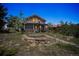 Charming cabin with a stone garden, surrounded by lush greenery against a twilight sky, offers a peaceful retreat at 3945 Douglas Mountain Dr, Golden, CO 80403