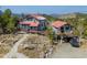 Stunning log home with red metal roof, nestled on a rocky landscape with incredible mountain views at 3945 Douglas Mountain Dr, Golden, CO 80403