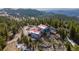 Mountain cabin nestled in the trees with a red roof and multiple decks at 3945 Douglas Mountain Dr, Golden, CO 80403