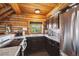 Well-lit kitchen with log walls, granite countertops, modern appliances, and a large window at 3945 Douglas Mountain Dr, Golden, CO 80403