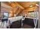 Cozy kitchen featuring log walls, wooden staircase, granite countertops, and stainless steel appliances at 3945 Douglas Mountain Dr, Golden, CO 80403