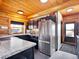 Bright kitchen featuring wood paneling, stainless steel appliances, and black cabinetry at 3945 Douglas Mountain Dr, Golden, CO 80403
