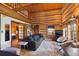 Comfortable living room with log walls, stylish furniture, and an open doorway to bedroom at 3945 Douglas Mountain Dr, Golden, CO 80403